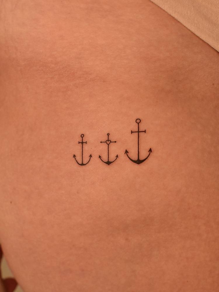 Minimalistic little anchors tattoo located on the pelvis.