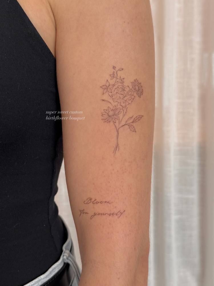 Bloom for yourself and flower bouquet tattoos located on the upper arm.