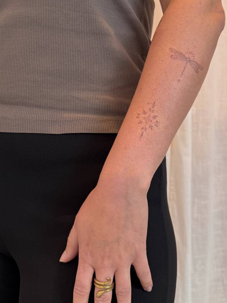 Fine line style dragonfly and ornament tattoos located on the forearm.