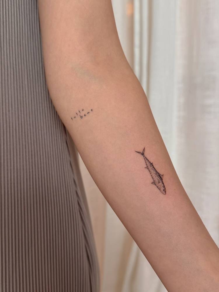 Illustrative style mackerel tattoo located on the inner forearm.