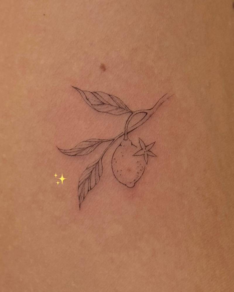 Lemon tattoo in fine line style located on the inner arm.