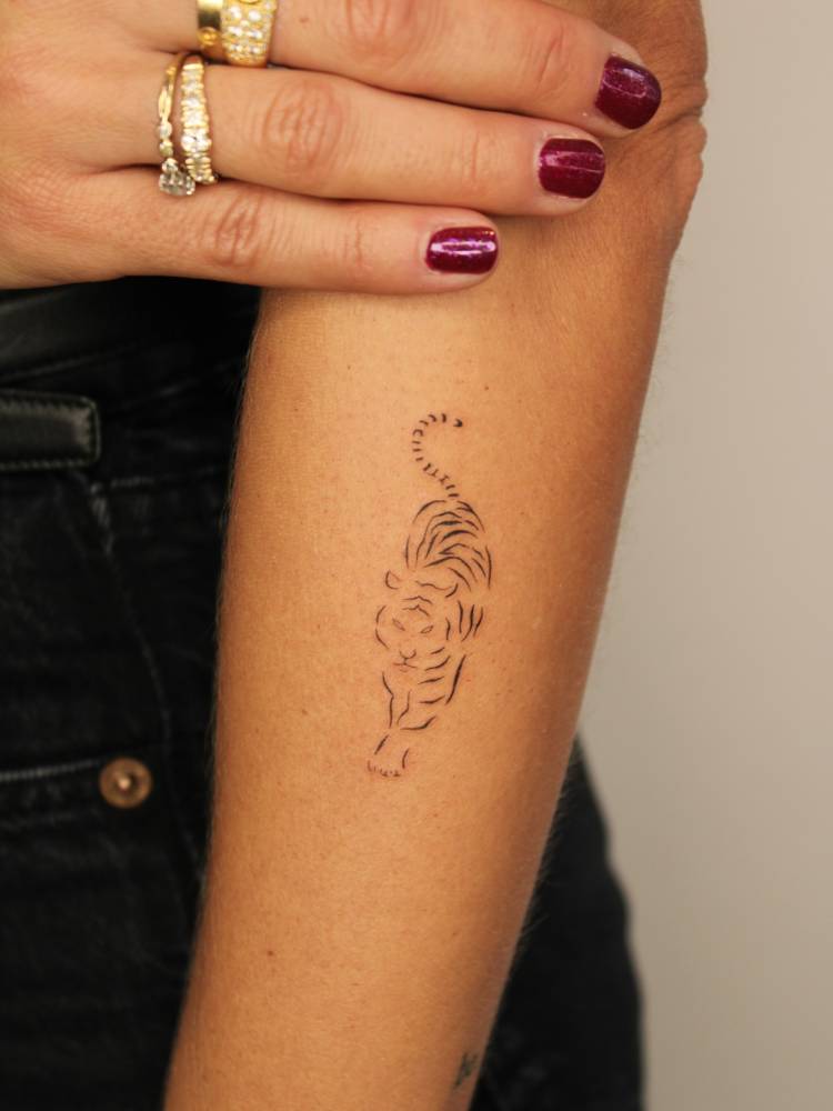 Fine line style tiger tattoo located on the forearm.