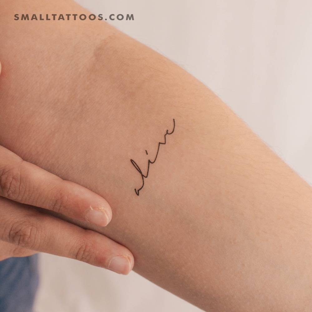 Handwritten font word "alive" temporary tattoo located on the inner forearm.