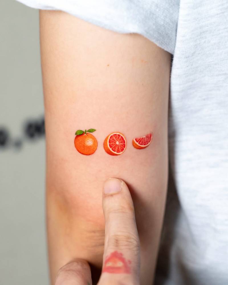 Micro-realistic style grapefruit tattoo located on the tricep.