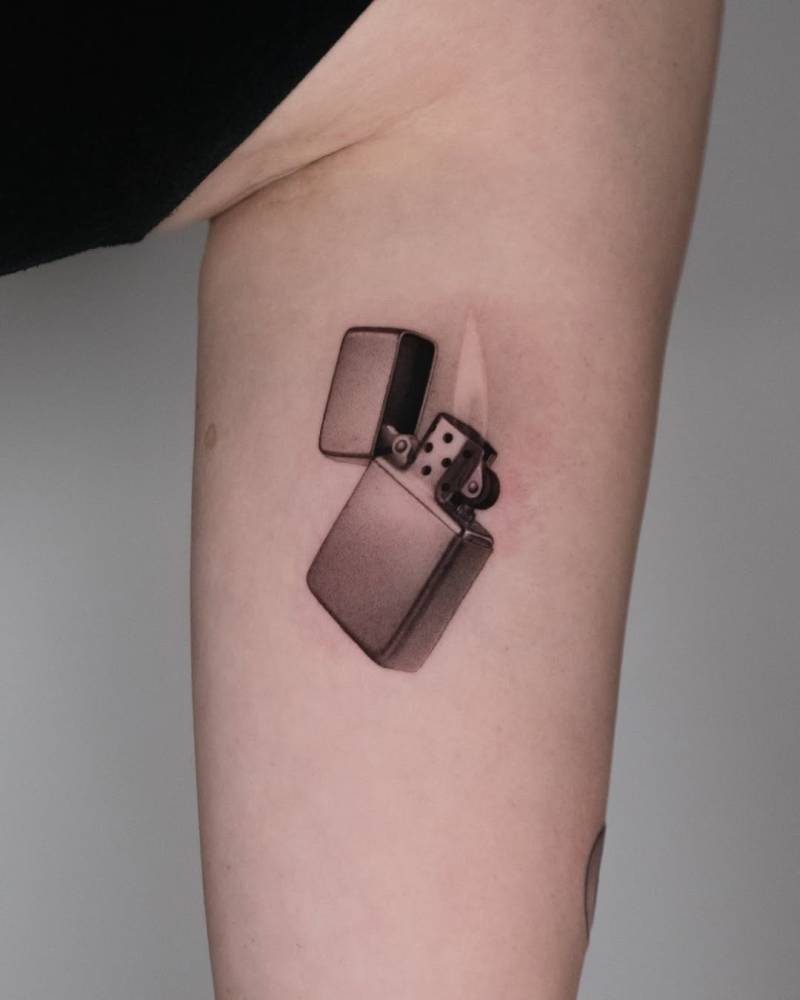 Micro-realistic style lighter tattoo placed on the inner arm.