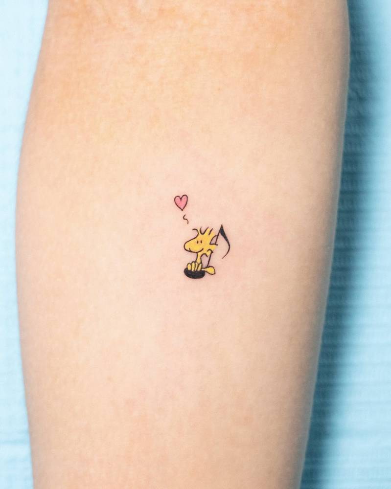 Woodstock tattoo in cartoon style located on the inner forearm.