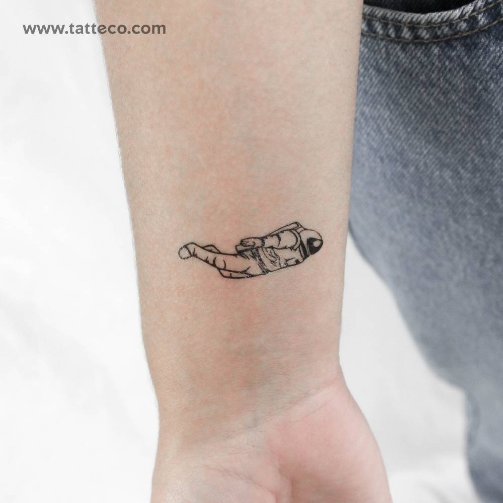 Astronaut temporary tattoo in illustrative style located on the wrist.