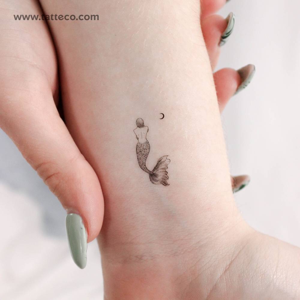 Mermaid and moon temporary tattoo located on the wrist.
