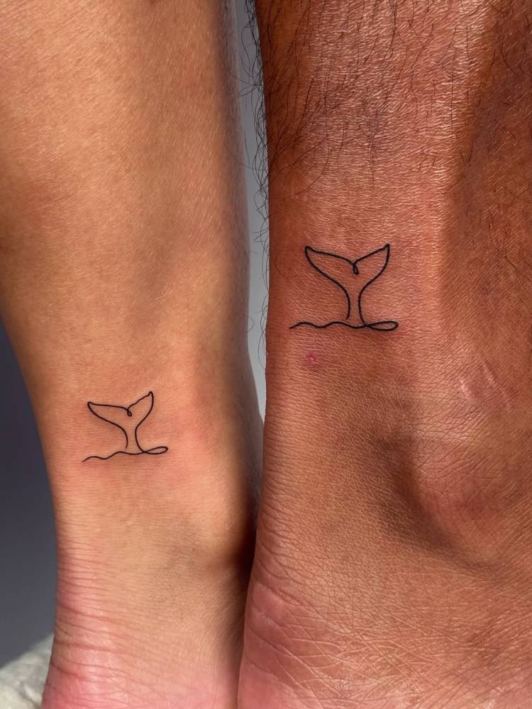Matching minimalistic whale tail tattoo for couple.
