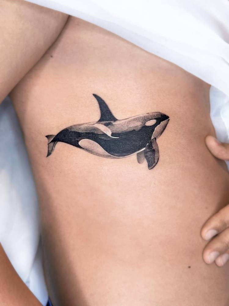 Orca tattoo in micro-realistic style located on the rib.