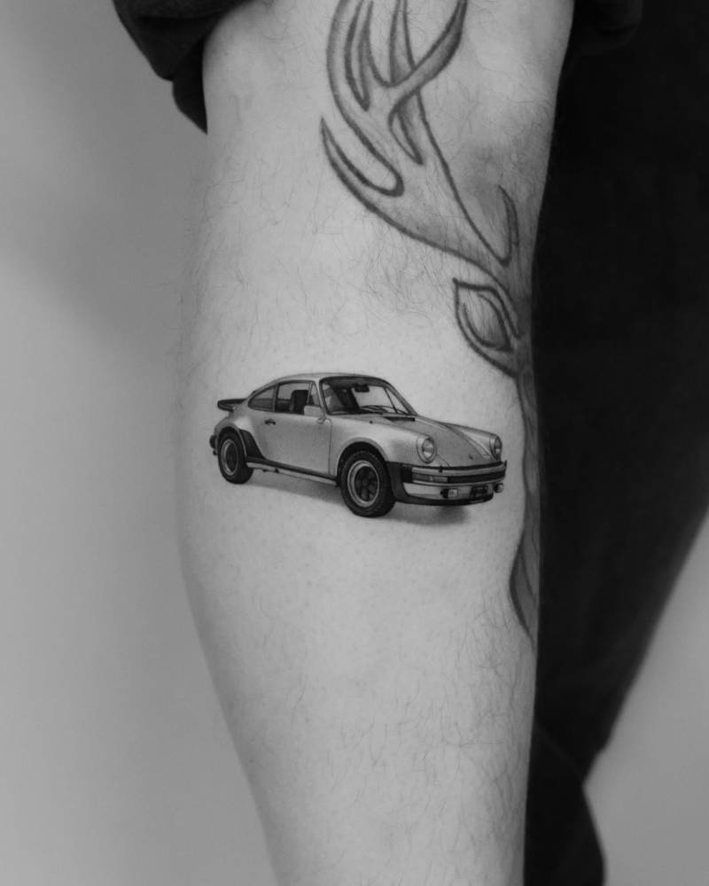 Micro-realistic style Porsche 911 tattoo located on the calf.
