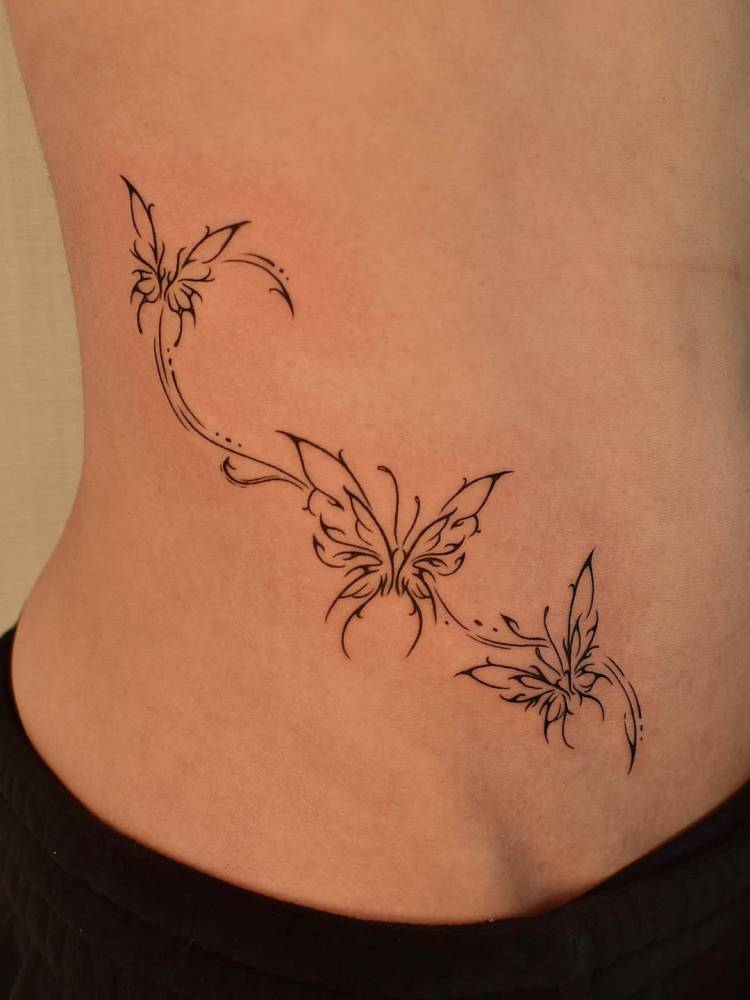 Tribal butterflies tattoo located on the waist.
