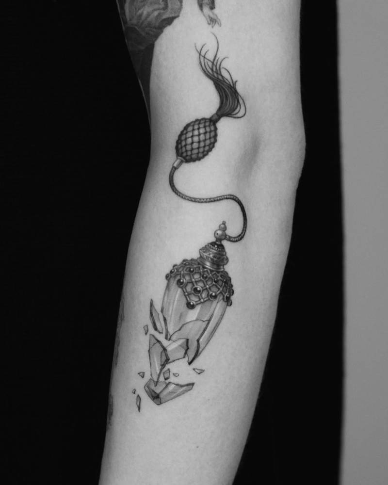Micro-realistic style air pump perfume tattoo located on the arm.