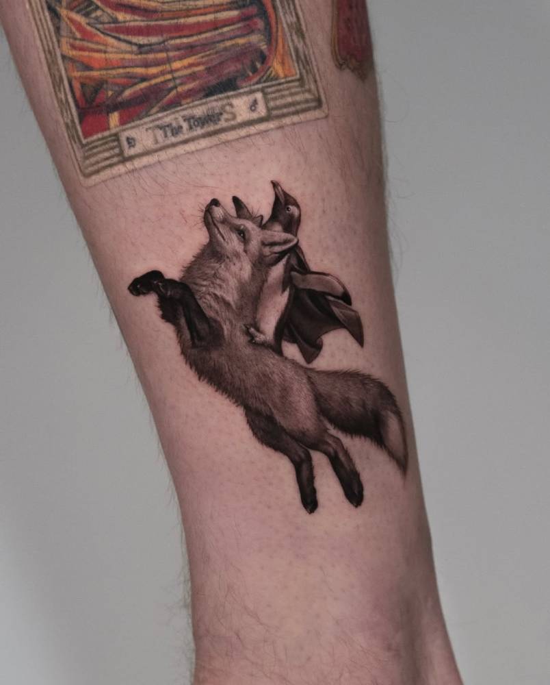Fox and penguins tattoo in micro-realistic style located on the shin.