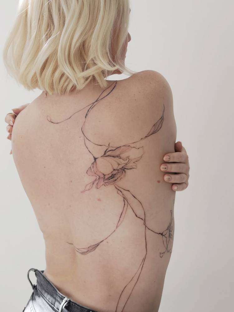 Rose tattoo in illustrative style located on the back.