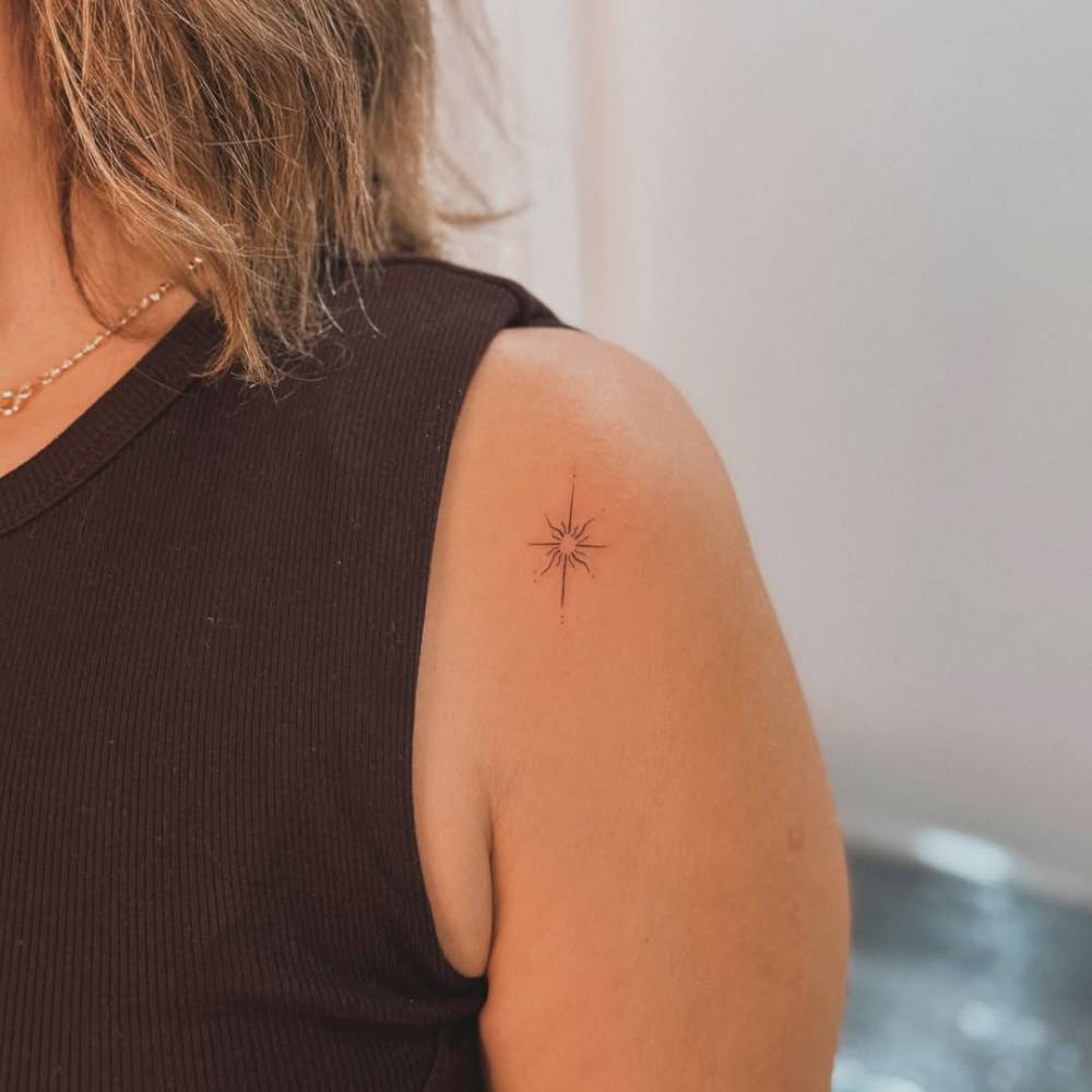 North star tattoo in fine line style placed on the shoulder.