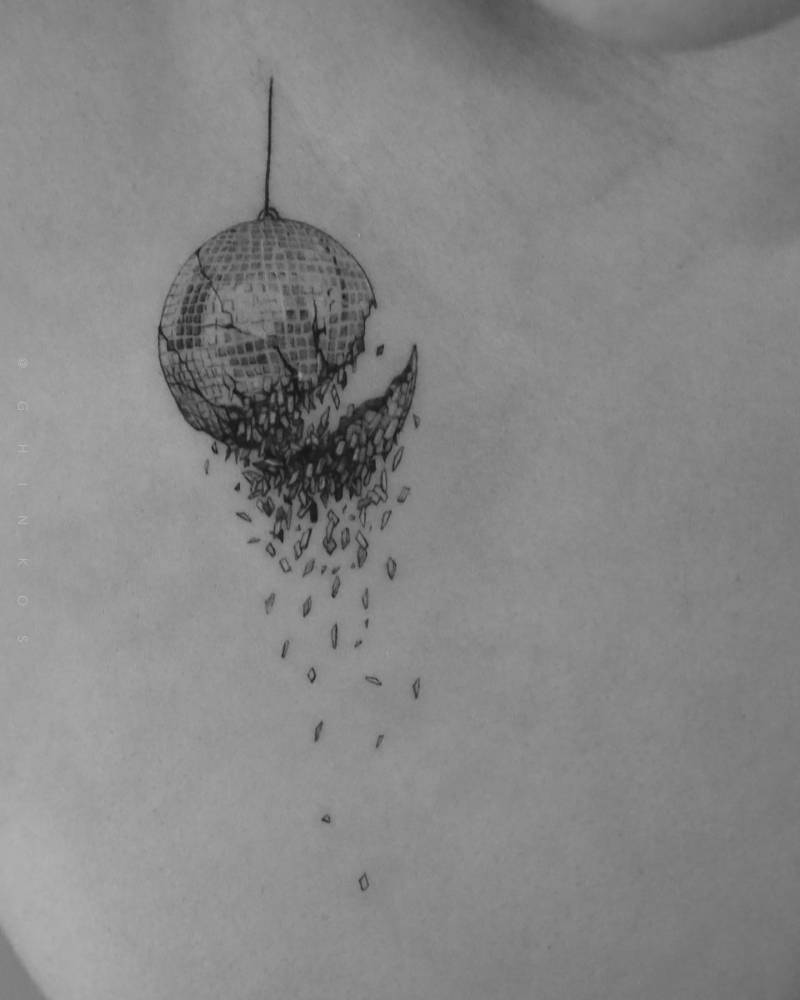 Micro-realistic style broken disco ball tattoo placed on the chest.