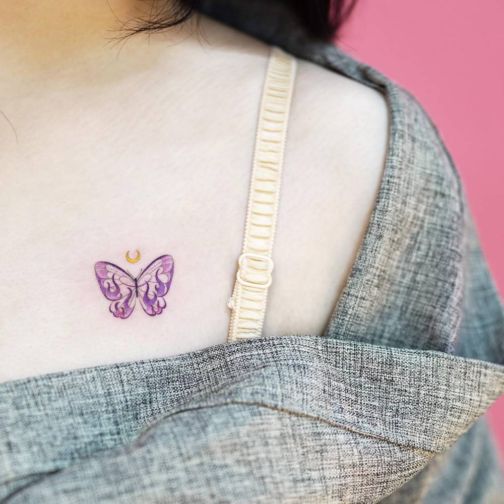 Pink butterfly tattoo placed on the chest.