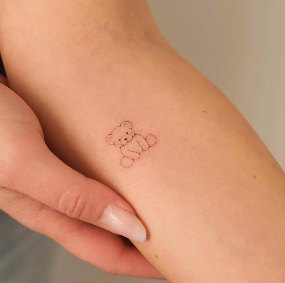 Cute teddy bear tattoo located on the inner forearm.
