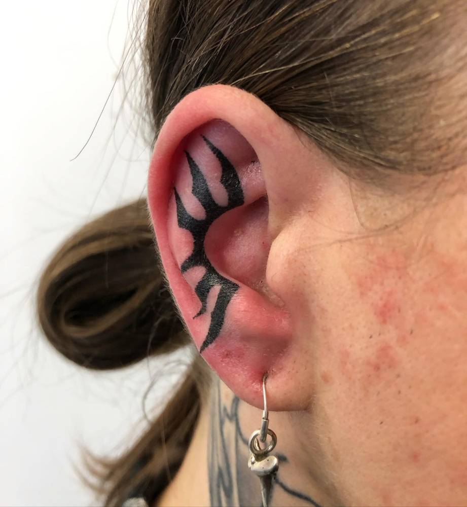 Tribal tattoo hand poked on the ear.