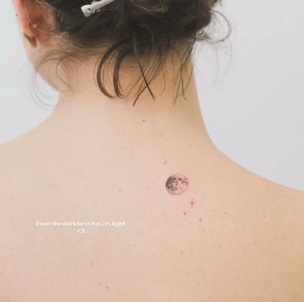 Single needle full moon tattoo located on the upper back.