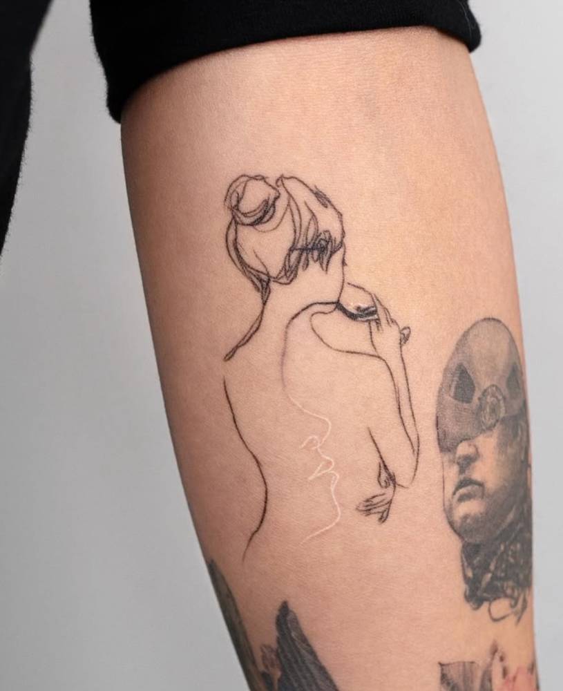 Sketch work style woman drinking wine tattoo located on the inner forearm.