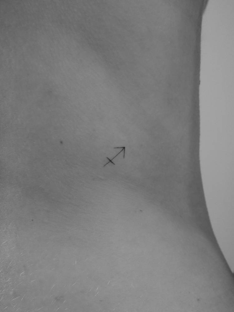 Sagittarius zodiac symbol tattoo located on the back, minimalistic style.