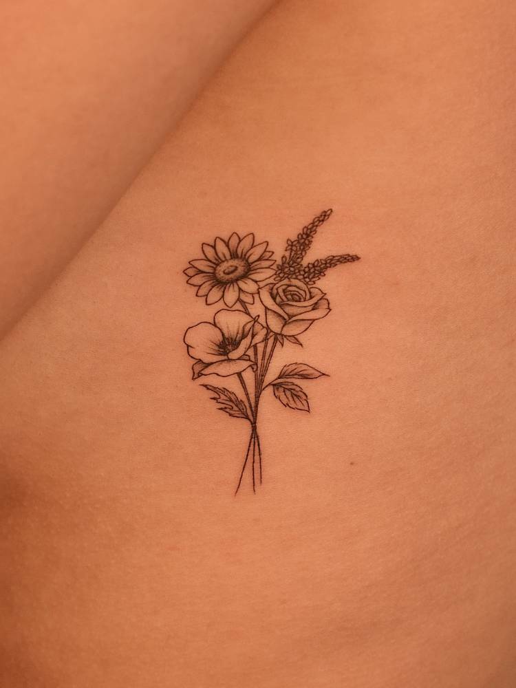 Flower bouquet tattoo in illustrative style located on the side boob.
