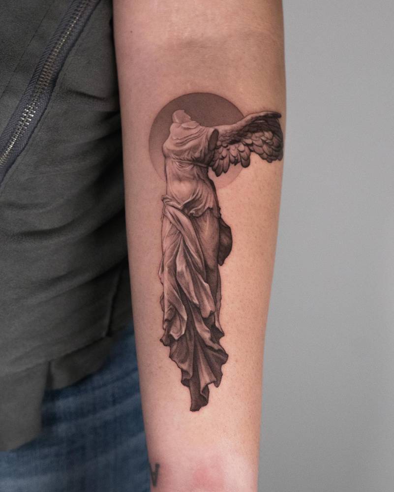Nike of Samothrace tattoo in micro-realistic style located on the inner forearm