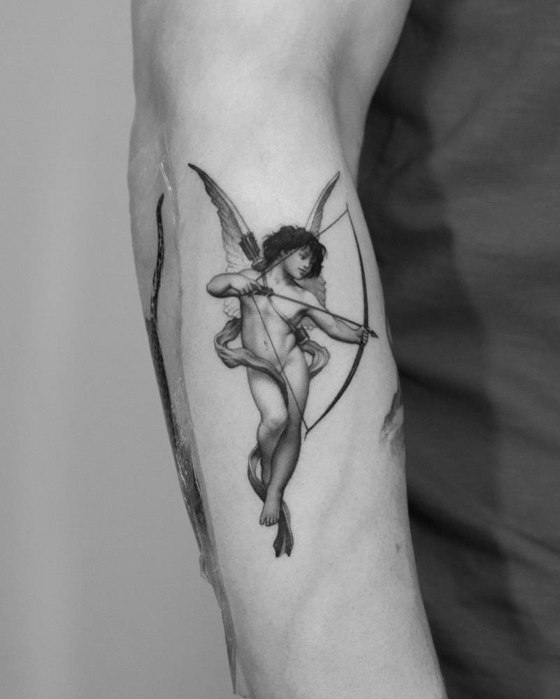 Micro-realistic Cupid tattoo located on the forearm.