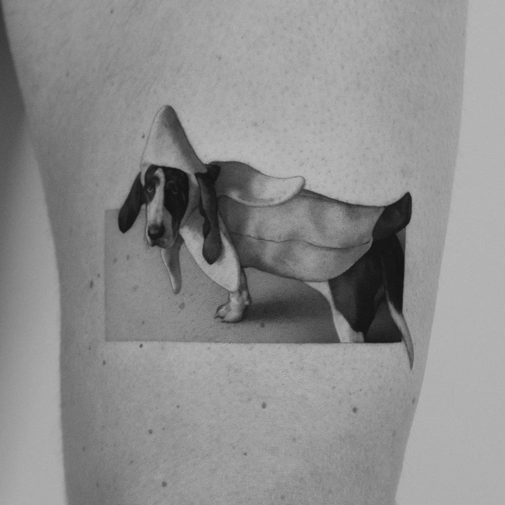 Basset Hound tattoo done on the thigh, micro-realistic style.