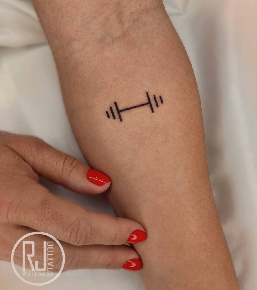 Dumbbell tattoo in minimalistic style located on the inner forearm.