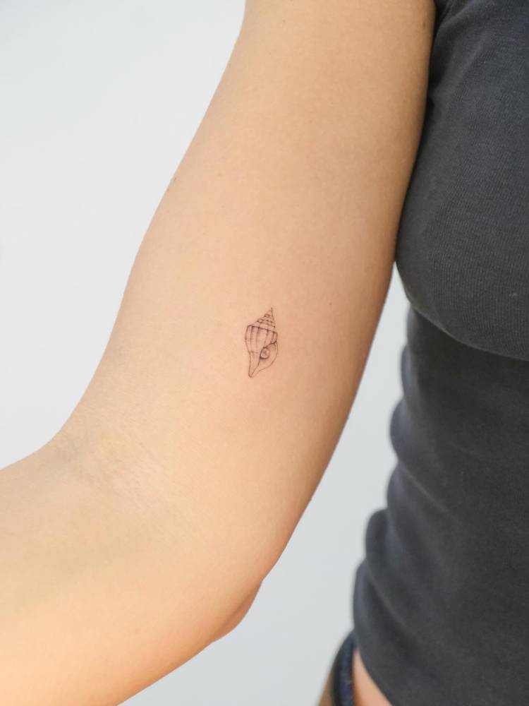 Single needle tiny tulip shell tattooed on the inner arm.