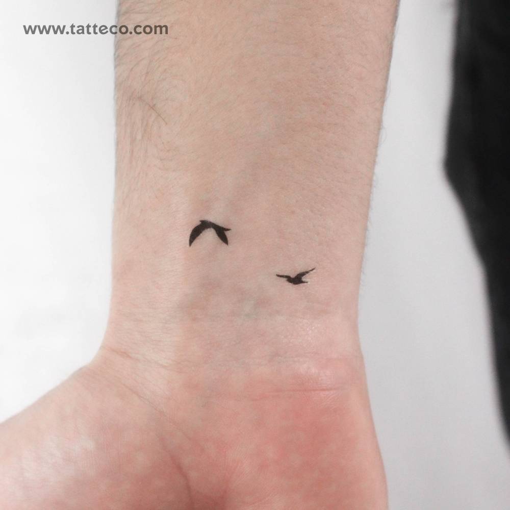 Two minimalistic flying birds temporary tattoo located on the wrist.