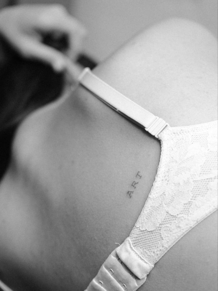 Typewriter font word "art" tattoo placed on the back.