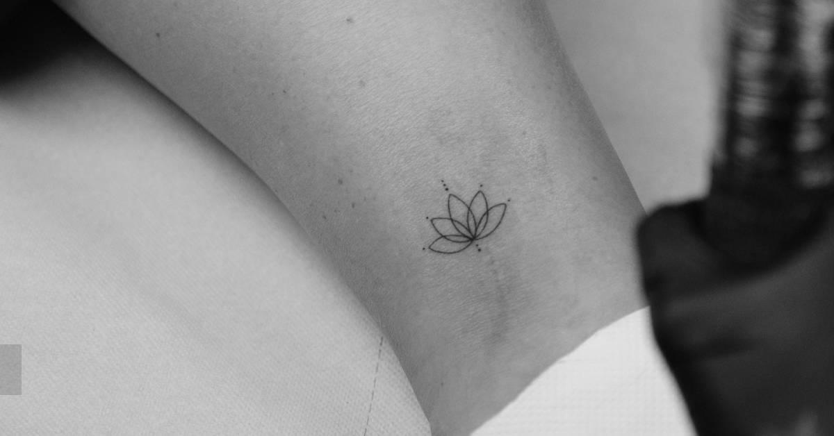 Small lotus flower tattoo in fine line style done on