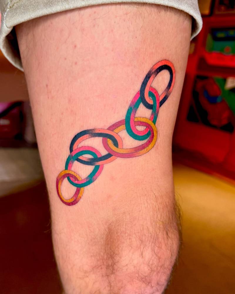 Colorful chain in illustrative style tattooed on the thigh.