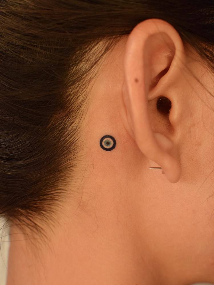 Little Nazar tattoo located behind the ear.