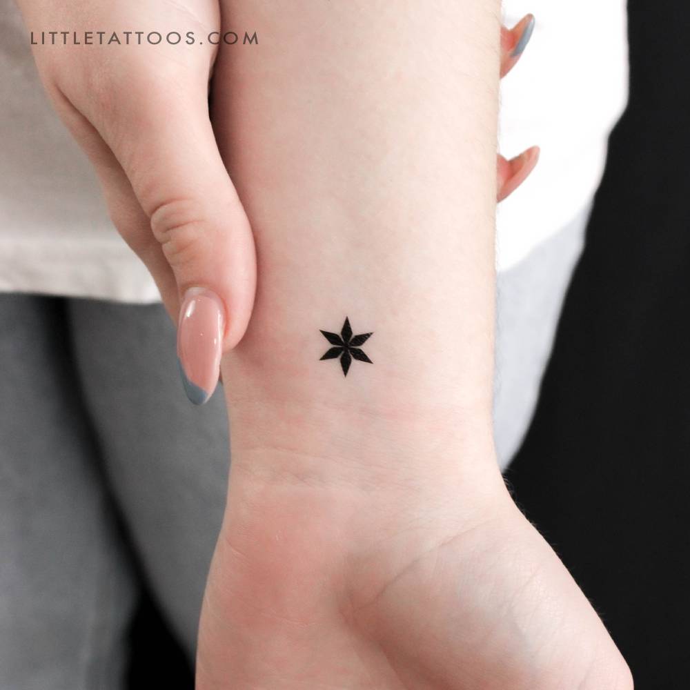 Tiny star ornament temporary tattoo located on the wrist.