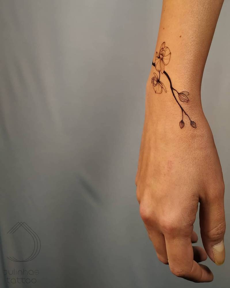 Orchid bracelet tattoo done on the wrist.