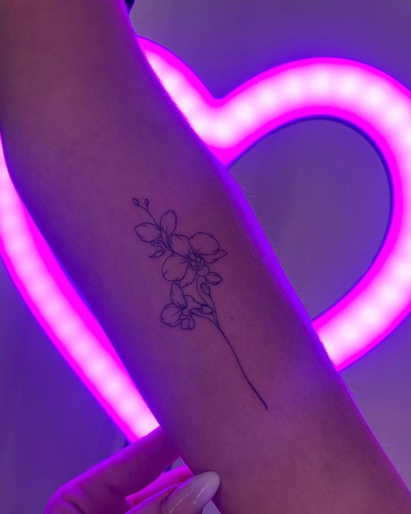 Fine line style orchids tattoo located on the inner forearm.