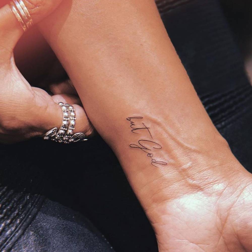 "But God" lettering tattoo on the wrist.