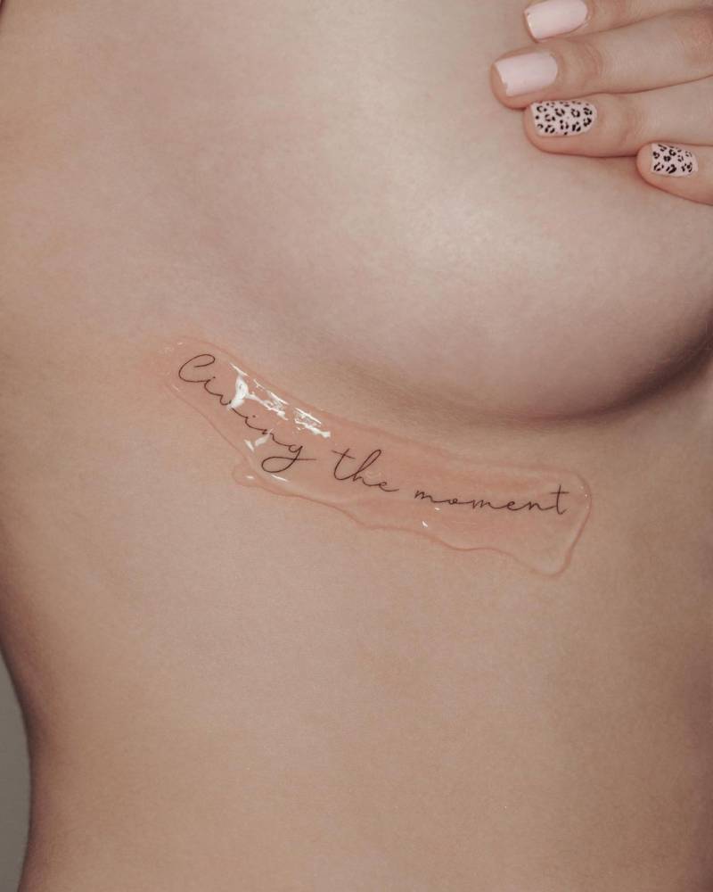 "Living the moment" lettering tattoo
