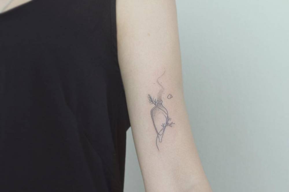 Fine line Felix Felicis tattoo on the bicep.