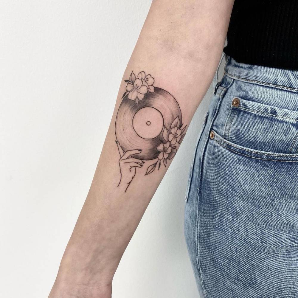 Vinyl record tattoo on the inner forearm.