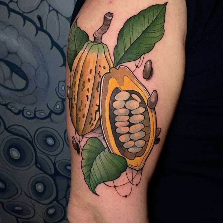 Neotraditional cocoa pod tattoo on the upper arm.