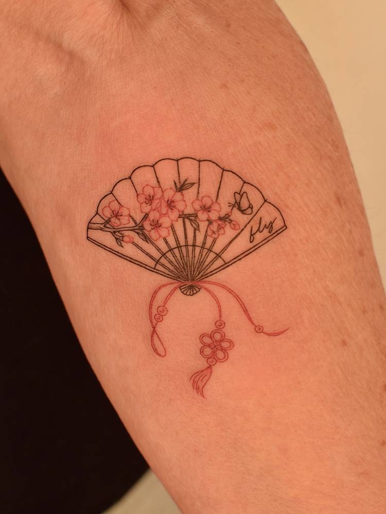 Fine line style hand fan tattoo located on the inner forearm.