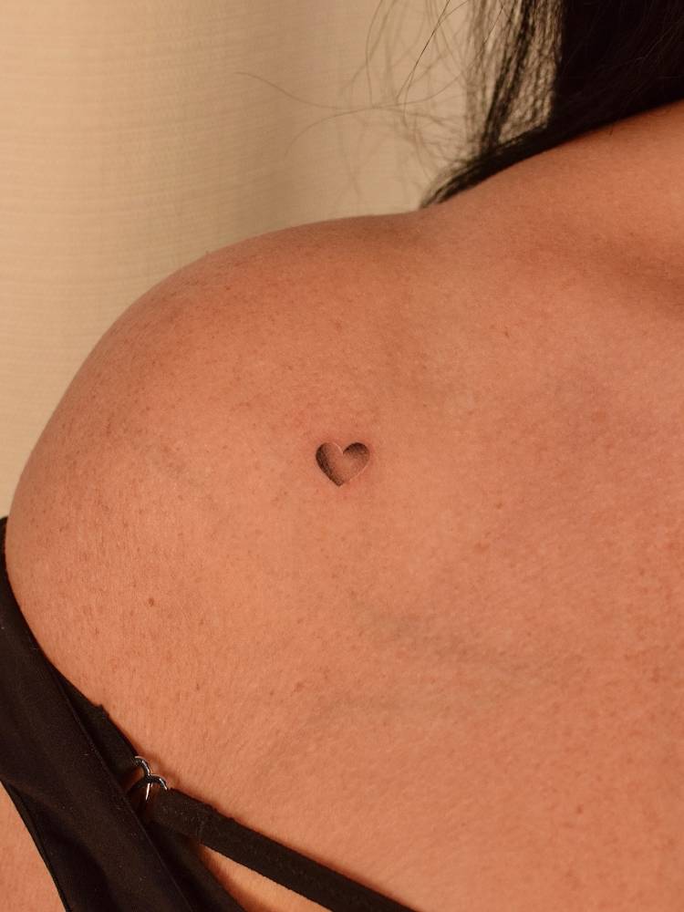 Mini spectrum heart tattoo located on the shoulder.