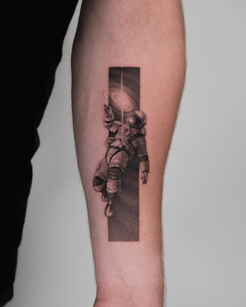 Astronaut tattoo located on the inner forearm, done in micro-realistic style.