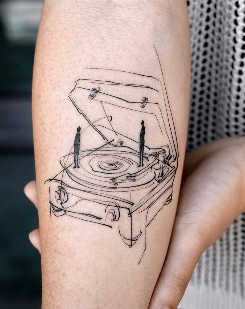 Sketch work style turntable tattoo located on the inner forearm.